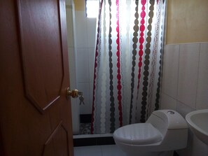Une salle de bain avec des toilettes, un lavabo et un rideau de douche.