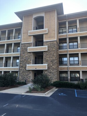 A multi-story building with a stone facade and multiple balconies.