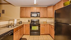 A kitchen with wooden cabinets, a stainless steel refrigerator, a microwave, a stove, and a dishwasher. - Location, location, location! 2br/2bath condo in the heart of Pigeon Forge (Pigeon Forge)