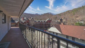 Ein Balkon mit Blick auf ein Wohngebiet, inklusive Häuser und einem Berg im Hintergrund.