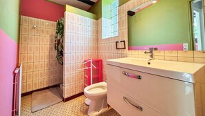 Une salle de bain équipée de toilettes, d’un lavabo et d’une douche.