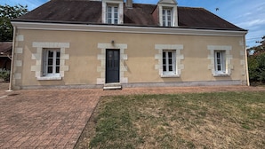 A two-story house with a beige facade, a black front door, and two small windows on the upper floor. - Family Getaway: Heated Pool, Near Zoo de Beauval, Tennis, Garden, 4 Bedrooms (Villentrois-Faverolles-en-Berry)