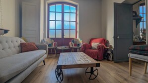 Una sala de estar con sofá, sillas, una mesa de centro y un ventanal con vistas.