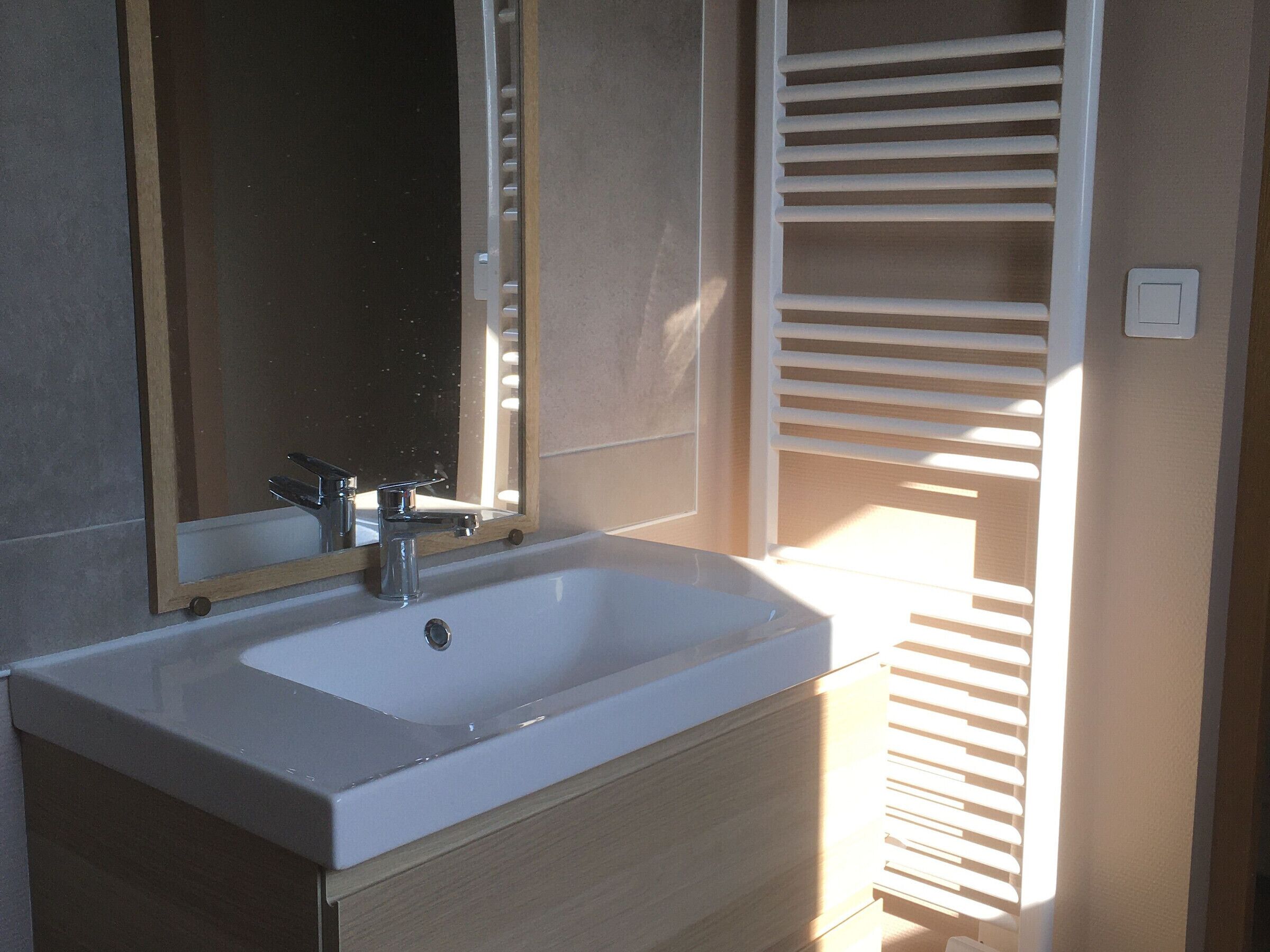 Ein Badezimmer mit Waschbecken, Spiegel und Handtuchhalter.