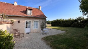 A house with a red-tiled roof, a small window, and a gravel driveway leading to a white door. - Peaceful cottage in Berry, family ideal (Sainte-Fauste)