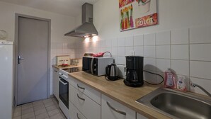 A modern kitchen with white cabinets, a stainless steel sink, a coffee maker, and a toaster.
