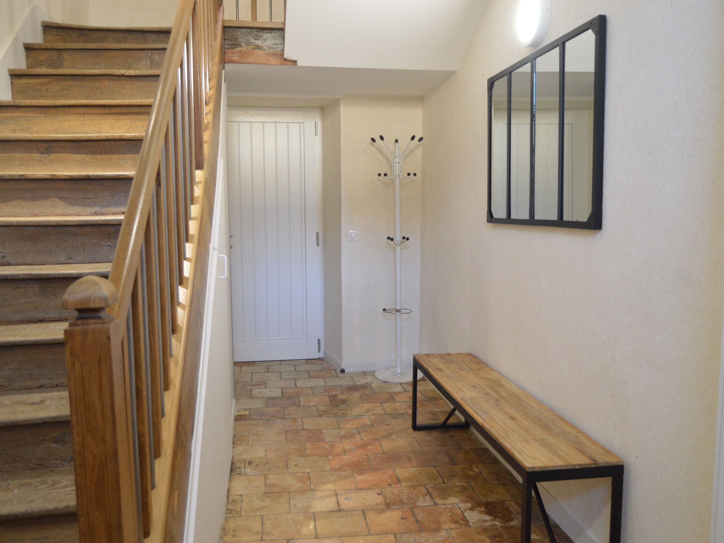 Un escalier avec des marches en bois menant à une porte blanche.
