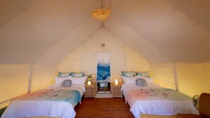 A tented accommodation with two beds, each with a bedside table and lamp, and a hanging light fixture. - Nayang Beach (Taichung)