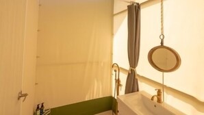 A compact bathroom with a green ceiling, a white sink, and a mirror. - Nayang Beach (Taichung)