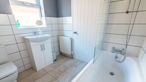 A bathroom with a white sink, toilet, and bathtub. - Platform Avenues House (Hull)