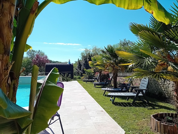 Ein Poolbereich mit Liegestühlen und einem Weg zu einem Gebäude.