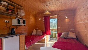 Un chalet confortable avec deux lits, une kitchenette et un petit coin repas.