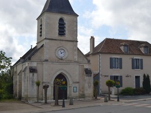 Eine Kirche mit einem Glockenturm und ein traditionelles Gebäude mit einem Ziegeldach.