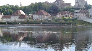 Eine Flussstadt mit historischen Gebäuden, darunter eine markante Kirche auf einem Hügel.