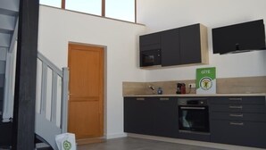 Una cocina moderna con armarios oscuros, un microondas y una cafetera.