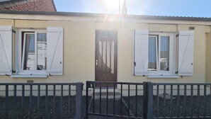 A building with a beige facade, white shutters, and a brown door. - Charming Townhouse with Garden, Near Downtown Châteauroux (Châteauroux)