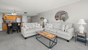 Una sala de estar moderna con un sofá modular, una mesa de centro y un comedor con sillas y una mesa.
