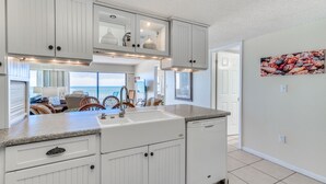 A kitchen with white cabinetry, a granite countertop, and a dishwasher.