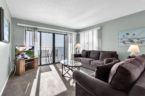 Relax on the spacious balcony with a glass door, taking in the view of the outdoors.