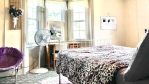 A bedroom with a bed, a chair, a desk, a fan, and a window with curtains. - Scenic Mountaintop Villa with Free WiFi & Pool (Waynesboro)