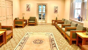 A cozy living room with a patterned carpet, wooden furniture, and a large window with curtains. - Scenic Mountaintop Villa with Free WiFi & Pool (Waynesboro)