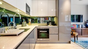 A modern kitchen with a dishwasher, oven, and a built-in TV.