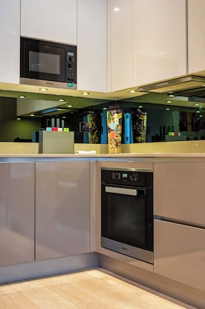 A modern kitchen with a built-in microwave, oven, and dishwasher.