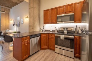 Une cuisine moderne avec des meubles en bois, des appareils en acier inoxydable et un îlot central.