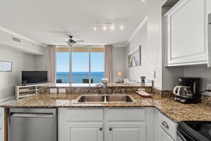 A modern kitchen with granite countertops, a double sink, a built-in dishwasher, and a stove. - Tidewater Beach Resort 2BD, 3BATH, and Ocean View (Panama City Beach)