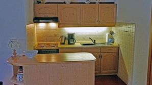 A small kitchen with wooden cabinets, a sink, and a countertop.