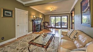 A living room with a fireplace, a sofa, and a coffee table. - Dock, Hot Tub & Kayaks: Luxe Hot Springs Lakehouse (Hot Springs)