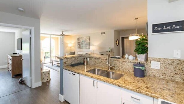 A modern kitchen with granite countertops, white cabinets, and a built-in sink. - Amazing view in Aventura! Cozy 2 BD at the Yacht Club (Aventura)