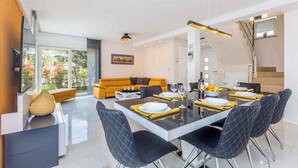 A modern dining area with a glass table, black chairs, and yellow placemats. - Villa with pool in the center of Malinska (Malinska)