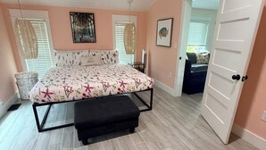 A bedroom with a bed, bench, and a door leading to another room. - WATER SLIDE & POOL ** SUGAR SHACK** (Bradenton)