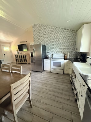 A modern kitchen with a built-in oven, refrigerator, and white cabinetry.