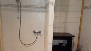 Un baño con ducha, lavabo e inodoro.