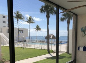A view of a pool area with palm trees and a building in the background. - Vibrant Family Condo with Pool & Ocean Panorama U3 (Marathon)