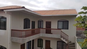 Un bâtiment à deux étages doté d’un balcon, de nombreuses fenêtres et d’un toit recouvert de tuiles.
