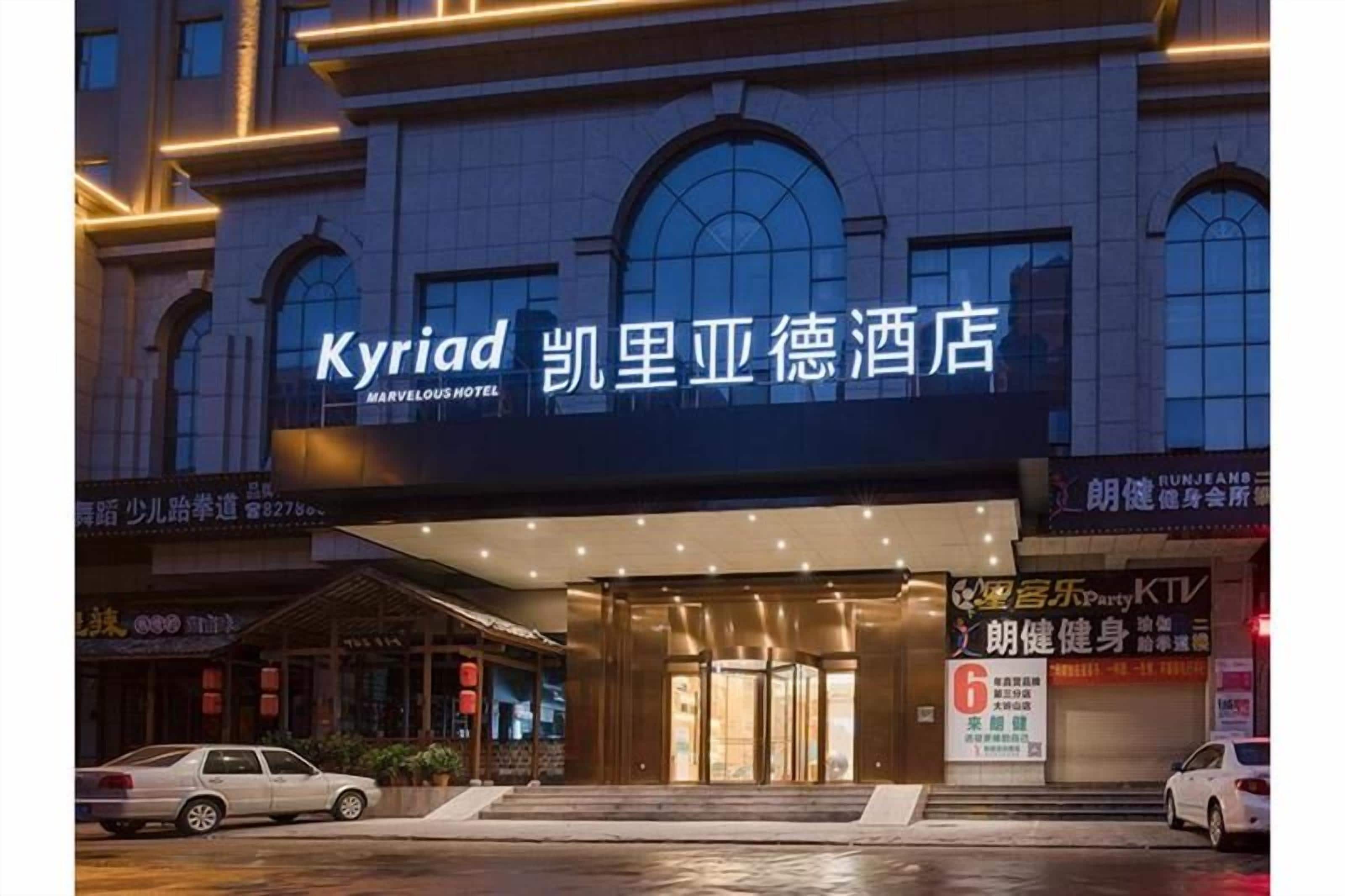 A hotel entrance with a marquee sign, a visible entrance, and a sign for a fitness center.