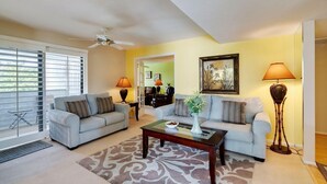 A living room with two light grey sofas, a wooden coffee table, and a patterned rug. - Paradise in Palm Springs, Cozy Condo 2BDR/2BA + Den, Balcony with Pool View (Palm Springs)