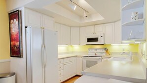 A modern kitchen with white cabinets, a microwave, an oven, and a sink. - Paradise in Palm Springs, Cozy Condo 2BDR/2BA + Den, Balcony with Pool View (Palm Springs)