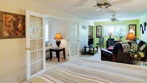A bedroom with a bed, two lamps, a desk, a chair, and a ceiling fan. - Paradise in Palm Springs, Cozy Condo 2BDR/2BA + Den, Balcony with Pool View (Palm Springs)