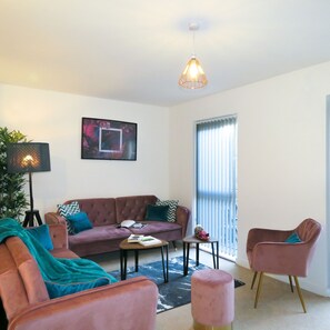 A living room with a sofa, armchairs, a coffee table, and a floor lamp.