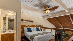 A bedroom with a bed, bedside table, TV, and a ceiling fan. - Beautiful, Family Friendly 2 Br 2Ba Across Street From Beach. (Kihei)
