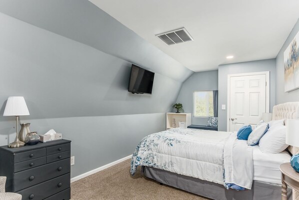 A bedroom with a bed, a dresser, a TV mounted on the wall, and a door. - ★The Mad Cat Inn★Private Guest House★ FirePit★HotTub★ (Lewis Center)