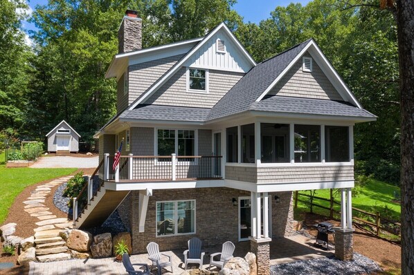 Une maison à deux étages, avec des fondations en pierre, un balcon et une véranda.