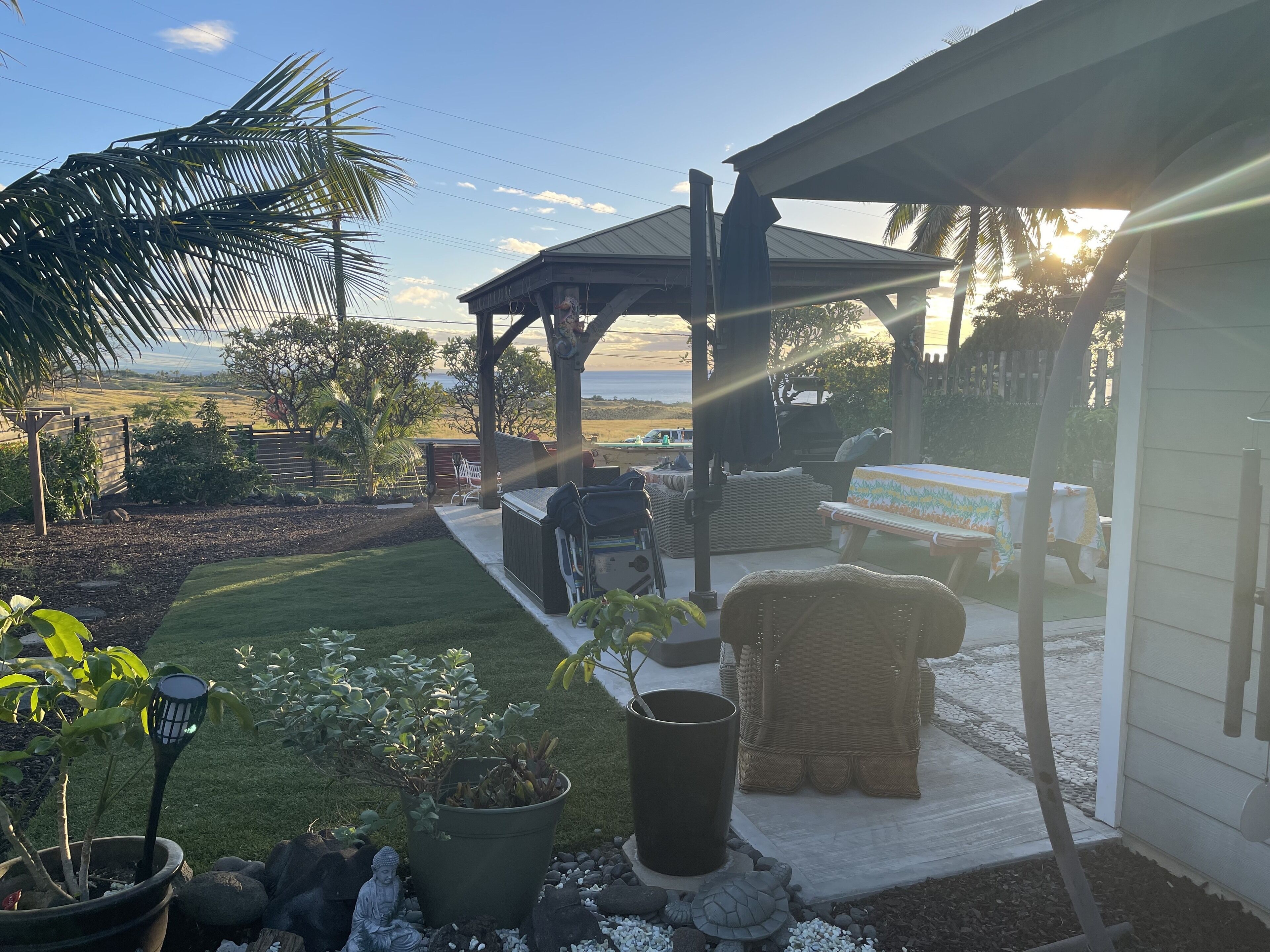 Eine Terrasse mit Gartenmöbeln, einer Pergola und Blick auf den Ozean.