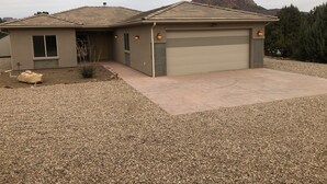 A single-story house with a garage, a covered patio, and a gravel driveway. - Southern Utah getaway  (Apple Valley)
