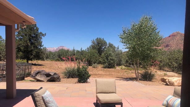 An outdoor patio with seating and a view of a natural landscape. - Southern Utah getaway  (Apple Valley)