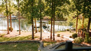 A lakeside property with a dock, a covered boat house, and a small cabin. - THANKSGIVING on Lake Keowee! Sleeps 18, Dock, Fire Pits, Kayaks, Pet Friendly (Seneca)